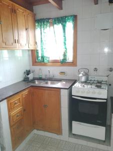 a small kitchen with a stove and a sink at Casa en la costa in Necochea