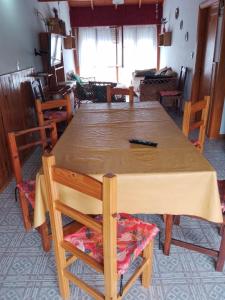 a wooden table and chairs in a living room at Casa en la costa in Necochea