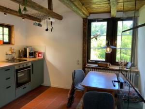 a kitchen with a wooden table and a table and chairs at Historische Breidenmühle in Haan