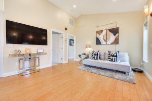 a living room with a white couch and a flat screen tv at Watch Dolphins St Augustine Gem Near Downtown! in Saint Augustine