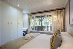 a bedroom with a large bed with a window at Knysna Lagoon - Lakeview Haven Chalet in Knysna +19 photos