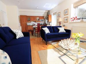 ein Wohnzimmer mit blauen Sofas und einem Tisch in der Unterkunft 6 Grafton Towers in Salcombe