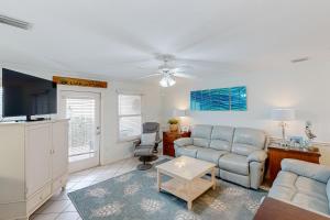 a living room with a couch and a tv at White Sands Retreat in Port Saint Joe