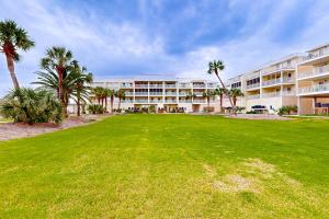 a large building with palm trees in front of a lawn at White Sands Retreat in Port Saint Joe