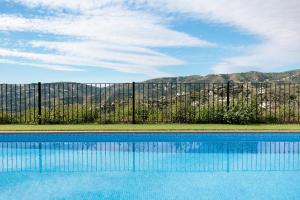 a swimming pool in front of a fence at Casa Ilusión in Frigiliana