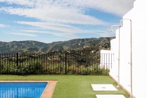 a house with a fence and a swimming pool at Casa Ilusión in Frigiliana