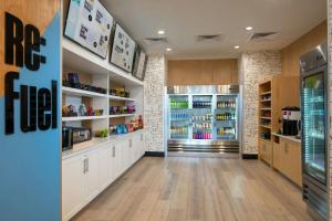 a kitchen with white cabinets and a large refrigerator at Aloft by Marriott Memphis Downtown in Memphis