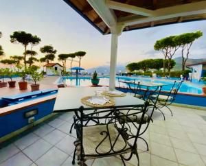a patio with a table and chairs next to a pool at Apartment San Nicola Arcella in Saracena