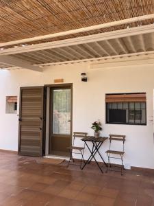 a patio with a table and chairs and a television at Apartamentos Carabela in Playa Migjorn