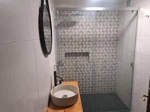a bathroom with a toilet and a glass shower at Casa dos Lamaceiros in São Vicente