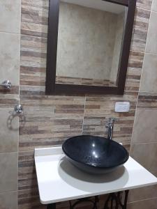 a bathroom with a black sink and a mirror at Casa la 12 in Miramar +3 photos
