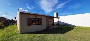 a small building with a window on a grass field at Casa la 12 in Miramar