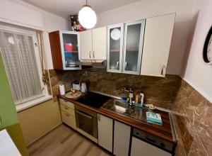 a small kitchen with white cabinets and a sink at StudioApartman-DANICA in Knin