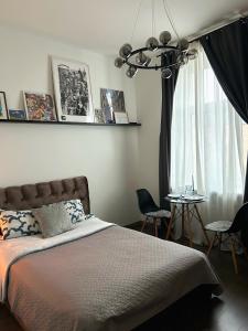 a bedroom with a bed and a window with chairs at Bonnie & Clyde's hideout in Rīga