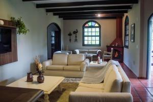 a living room with white couches and a fireplace at Sitio and Beach Tennis in Itatiba