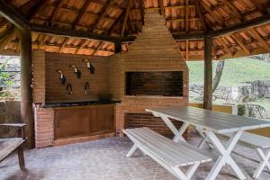 a outdoor kitchen with a table and a stove at Sitio and Beach Tennis in Itatiba