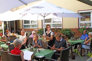 eine Gruppe von Personen, die in einem Restaurant an Tischen sitzen in der Unterkunft GROSCH Brauhotel & Gasthof in Rödental