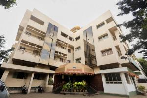 a large white building with a restaurant in front of it at Hotel Sai Prarthana Inn in Sangli