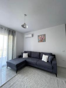 ティラナにあるTirana Terminal Apartmentsのリビングルーム(青いソファ付)