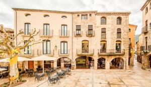a courtyard with tables and chairs in front of a building at Can Cintet 2-1,Nuevo Apartamento Moderno en Besalú in Besalú