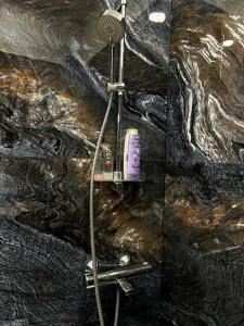 a shower in a bathroom next to a stone wall at Bonnie & Clyde's hideout in Rīga