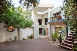 une maison blanche avec un escalier en face de celle-ci dans l'établissement African Rock Hotel and Spa, à Kempton Park