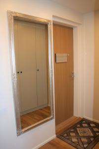 a mirror on a wall next to a door at Air conditioned condo downtown with lake view in Hämeenlinna