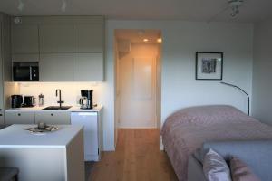 a small bedroom with a bed and a kitchen at Air conditioned condo downtown with lake view in Hämeenlinna