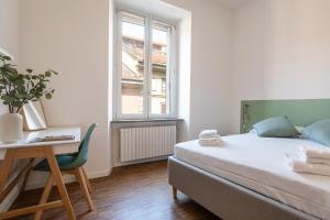 Un dormitorio con una cama y un escritorio y una ventana. en Bocconi District Suite - Bocconi Navigli - Milan-Cortina 2026 Olympics - Milan Design Week 2026, en Milán