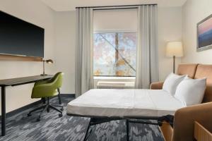 a hotel room with a bed and a desk and a window at Fairfield by Marriott Inn & Suites Kansas City at The Legends in Kansas City