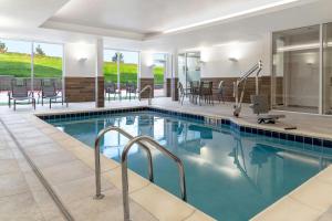 a pool in a hotel with chairs and tables at Fairfield by Marriott Inn & Suites Kansas City at The Legends in Kansas City