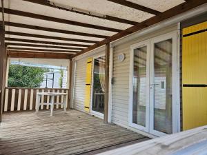 a porch with a table and a chair on it at mobil-home 6 couchages in Villeneuve-lès-Maguelonne