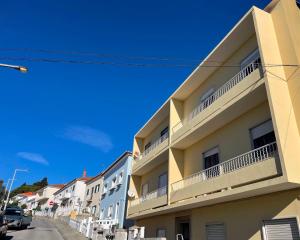 a building with white balconies on a street at Abrantes Urban Apartments in Abrantes