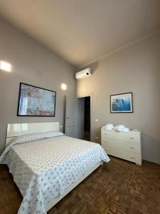 a bedroom with a white bed and a dresser at casa greta in Viareggio
