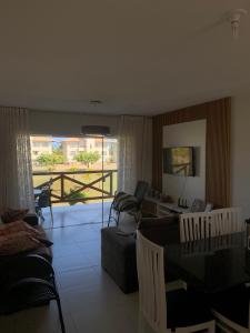 un soggiorno con divano e sedie e un balcone di Condomínio Villa das água, praia do saco a Estância Altre 8 foto