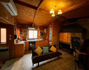 a living room with a couch and a kitchen at Casa Rústica Yemel Aike in Coihaique