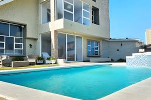 a swimming pool in front of a house at Casa de playa privada Sabanilla 4 cuadras del mar in Maizal