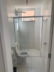 un bagno bianco con wc e doccia di Condomínio Villa das água, praia do saco a Estância