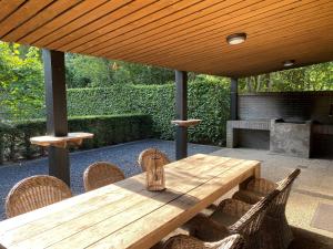 a wooden table and chairs under a wooden umbrella at de Tabaksschuur in Elst