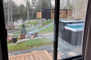 una vista da una finestra di un cortile con piscina di Emeraude des Sources Lac spa sauna et hammam a Brownsburg