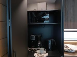 - une armoire noire avec une cafetière et un four micro-ondes dans l'établissement Saana's chalets Levi, à Levi