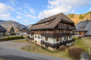 una gran casa de madera al lado de una calle en Galeriewohnung in Menzenschwand, en Menzenschwand-Hinterdorf