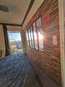 a bedroom with a brick wall and a window at Appartement de L'Espiguette in Le Grau-du-Roi