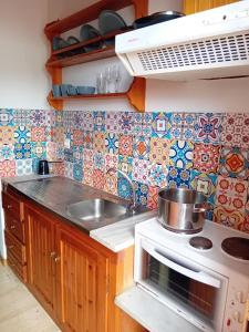 a kitchen with a stove and a sink and tiles at Villa Makis Studios in Skiathos Town