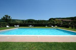 una piscina en la hierba con sillas alrededor en Chalet Luna di Miele - a due passi dalla Spiaggia, en Bolsena