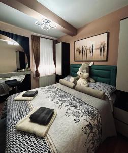 a bedroom with a teddy bear sitting on a bed at KARENJINA Apartmani in Vranje