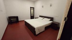 马拉利库兰Sandra Martha Villa的卧室里有一张铺着白色床单的大床 更多17张照片