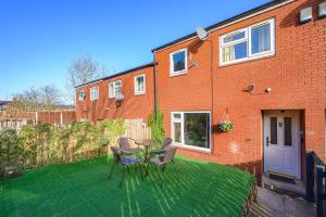a patio with a table and chairs on a lawn at -RAGS- For your relaxed, Cosy Stay, Free Parking in Leeds