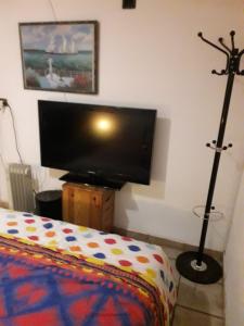 a bedroom with a flat screen tv and a bed at Chambre 4 in Bouc-Bel-Air