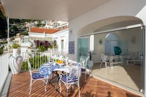 a room with a table and chairs on a balcony at Estate4home - Regina Dar adults only in Positano